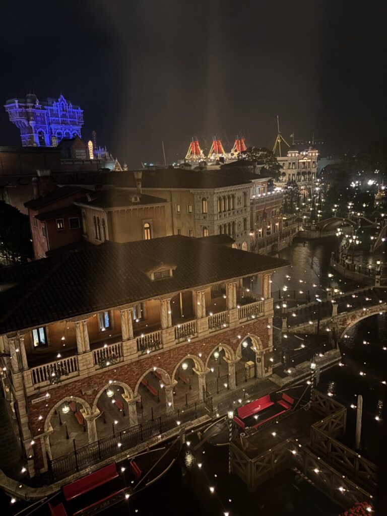 Nighat view of Tokyo DisneySea from Hotel MiraCosta showing Venetian Gondolas and illuminated park buildings