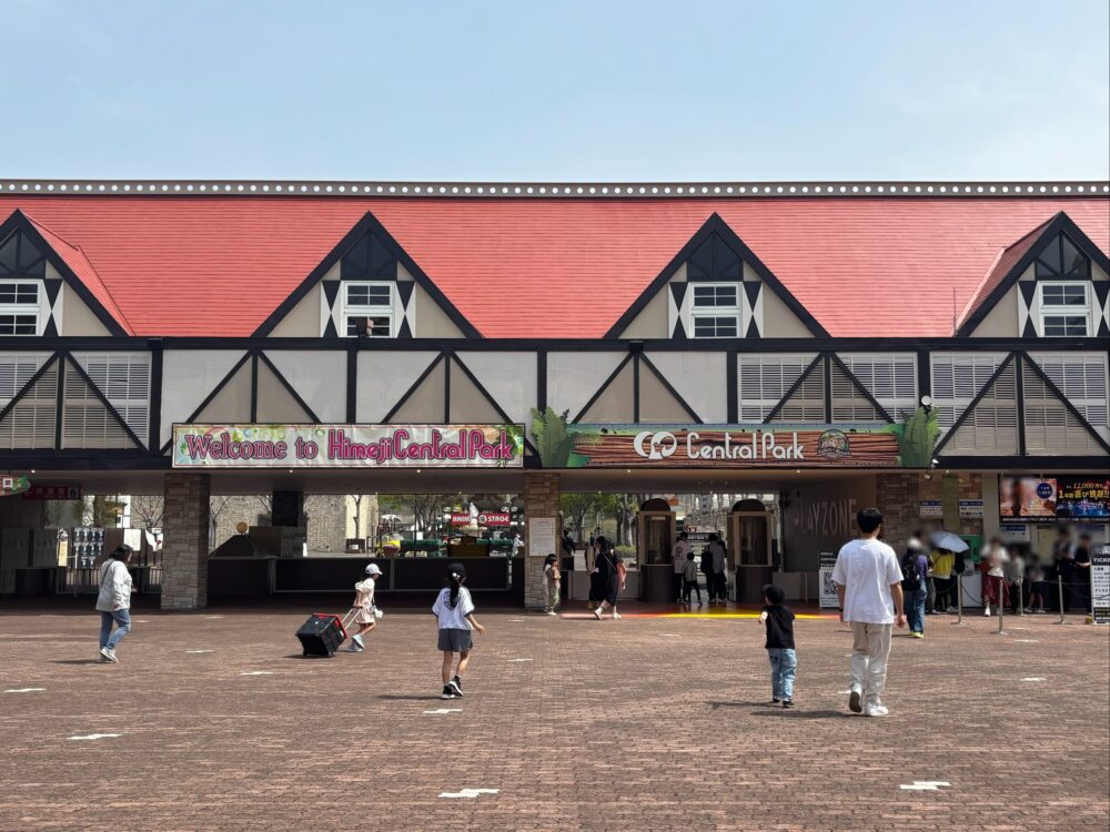 Entrance gate of Himeji Central Park with families and children entering on a sunny day