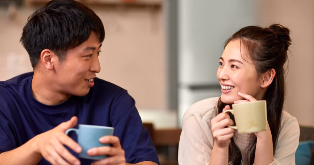 コーヒーカップを持った夫婦が仲良く笑顔で見つめ合う様子