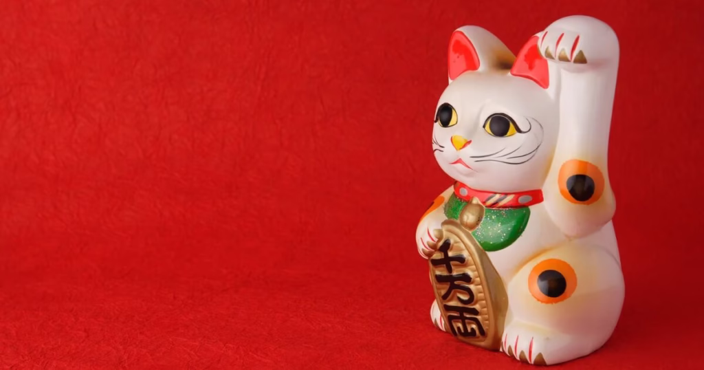 赤い背景に置かれた招き猫