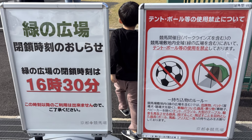 京都競馬場・緑の広場の注意看板。閉鎖時刻は16時30分で、競馬開催日はテントやボールなどの使用は禁止と案内されている。